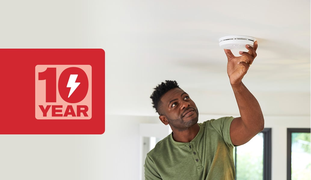 Man installing his fire alarm that has a 10 year battery life