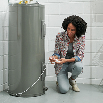 Homeowner is checking the water leak detector in the utility room.